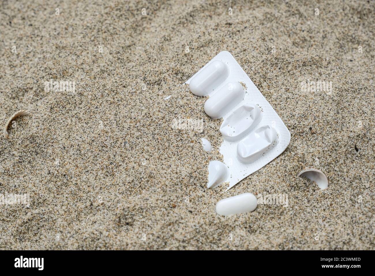 Plastique médecine blister contenant jeté pollution sur la côte de mer sablonneuse, cilento Banque D'Images