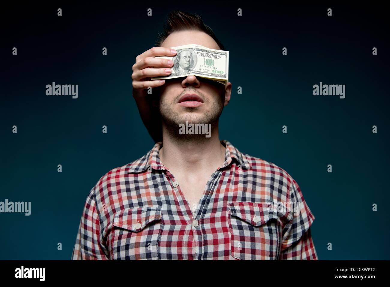 Les mains de l'obscurité ferment les yeux d'un travail homme avec des dollars Banque D'Images