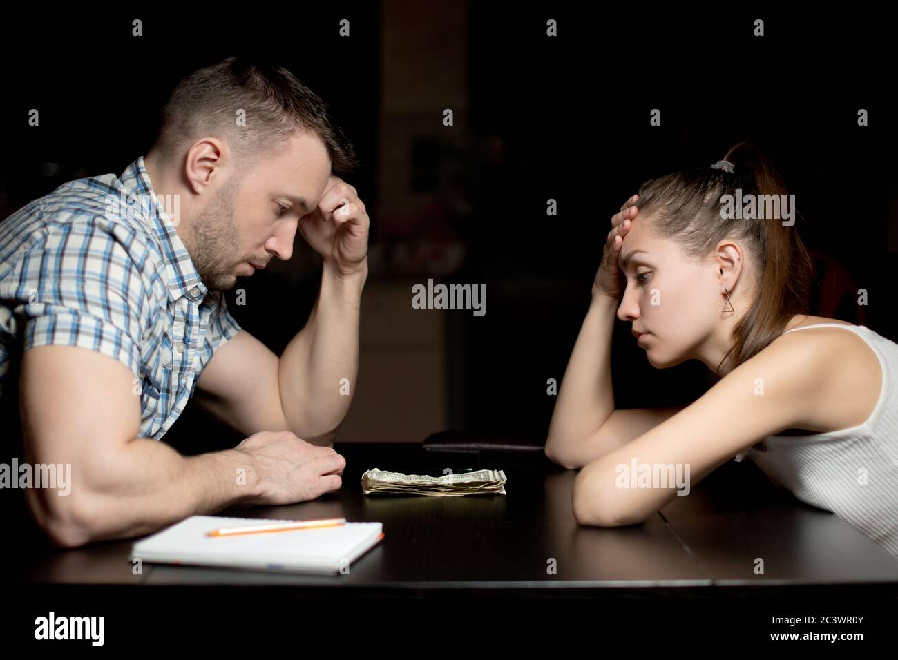 guy et fille regardent malheureusement des économies modestes d'argent en retard dans la soirée Banque D'Images