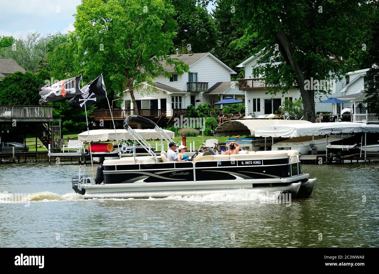 Bateau à ponton affichant deux drapeaux Jolly Roger qui navigue sur la rivière Fox dans le nord de l'Illinois. Banque D'Images