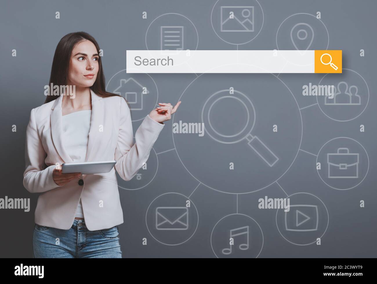 Femme d'affaires avec tablette pointant le doigt vers la barre de recherche, fond gris Banque D'Images