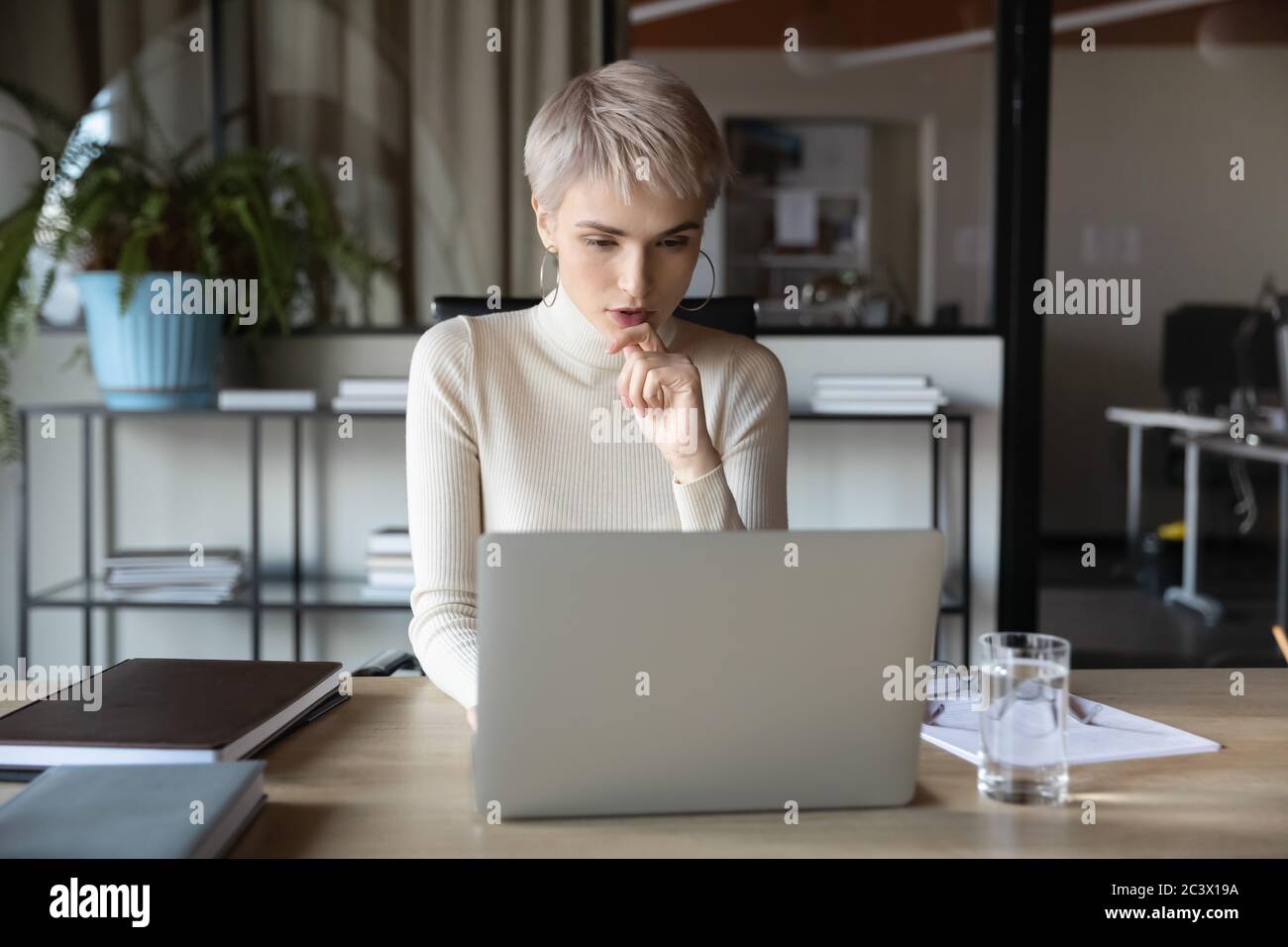 Femme d'affaires concentrée travaillant avec un ordinateur portable assis au bureau Banque D'Images