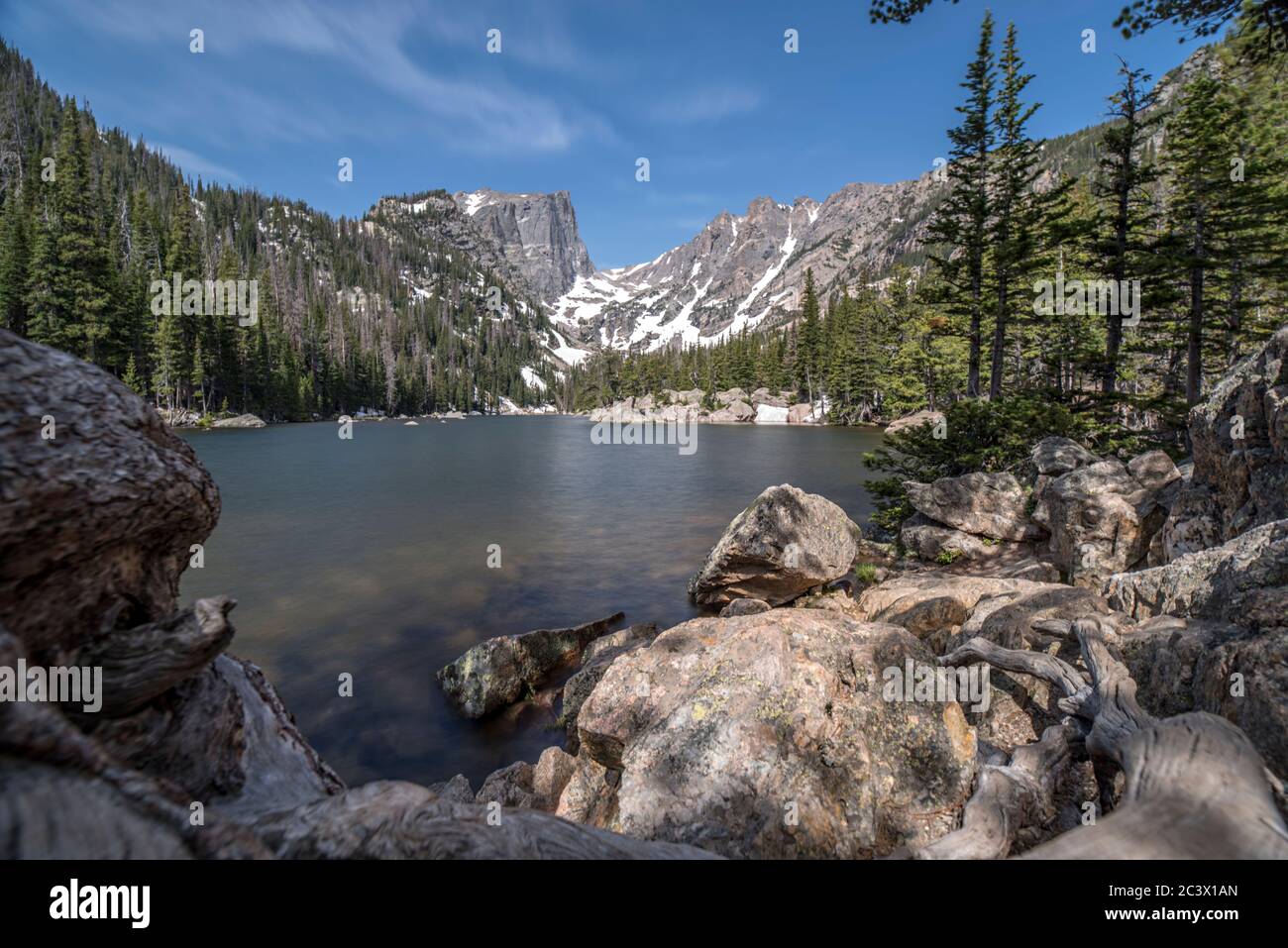 Lac Dream dans le parc national des montagnes Rocheuses avec des montagnes lointaines, des alpins et des conifères, des rochers de forêt et un ciel spectaculaire Banque D'Images