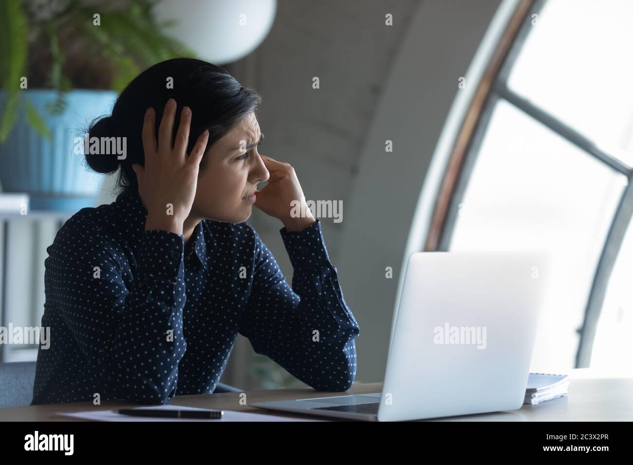 Un employé indien surtravaillé assis sur son lieu de travail souffrant de maux de tête Banque D'Images