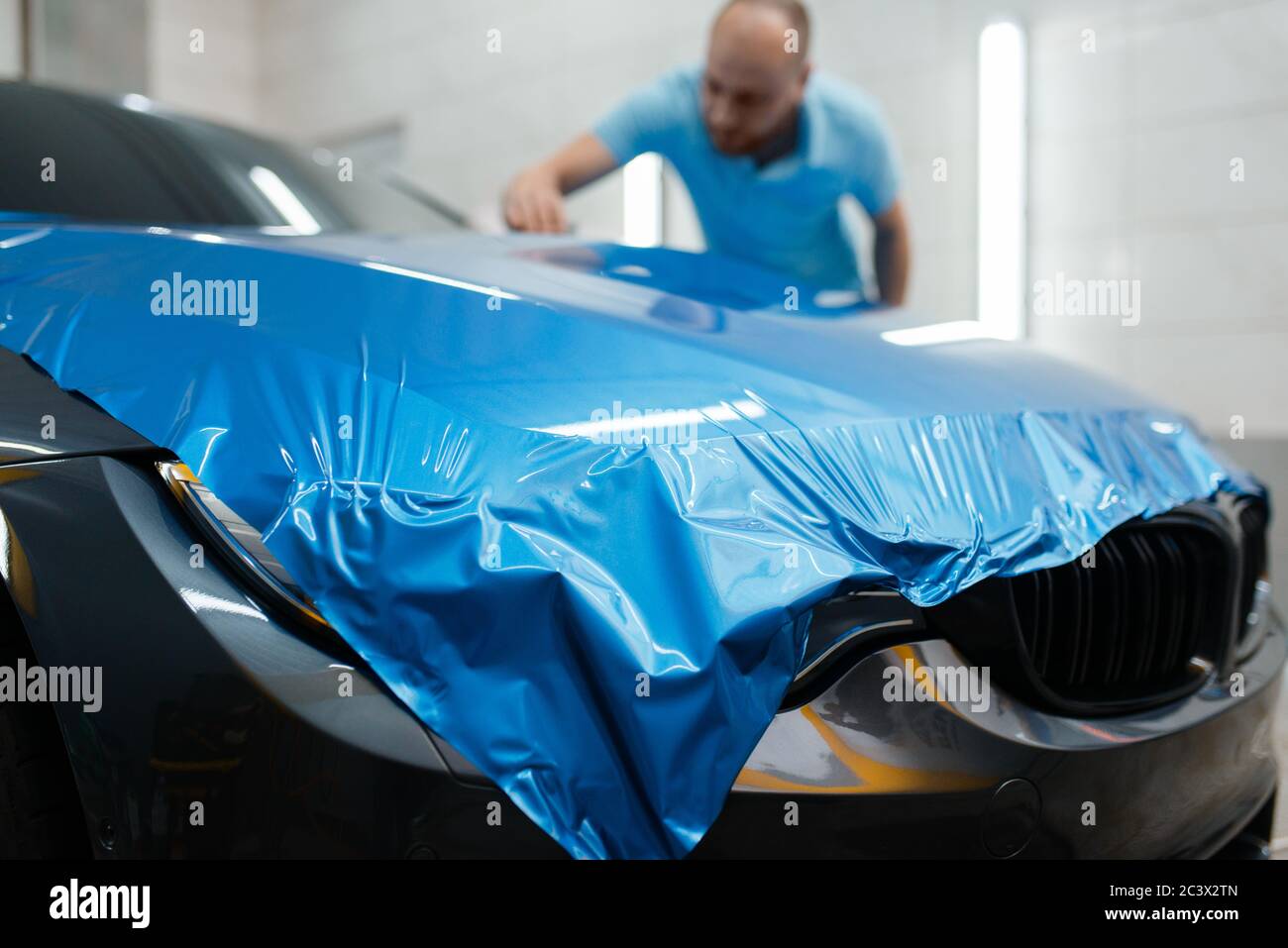 Emballage de voiture, homme installe le film de protection en vinyle Banque D'Images