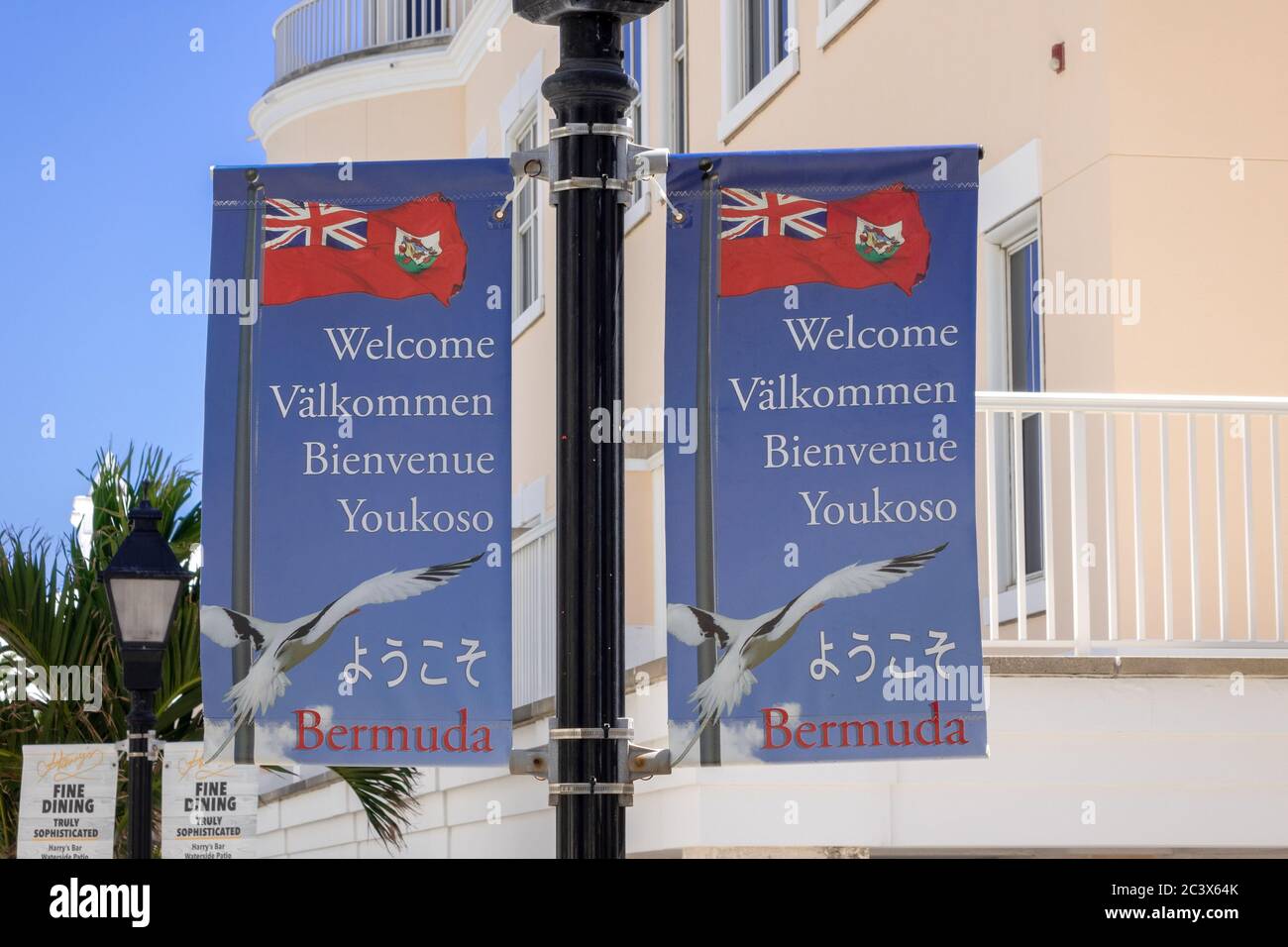 Bannières sur les lampadaire à Hamilton Bermudes Bienvenue aux Bermudes Signez des drapeaux dans plusieurs langues internationales Banque D'Images