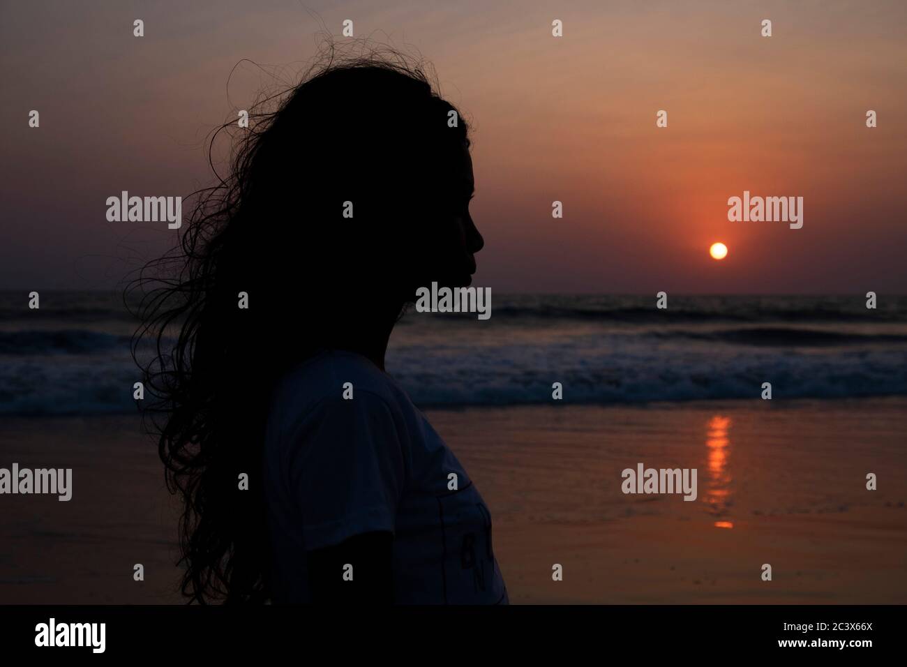 Silhouette de jeune femme au coucher du soleil sur la plage de Majorda à Goa, Inde. Banque D'Images