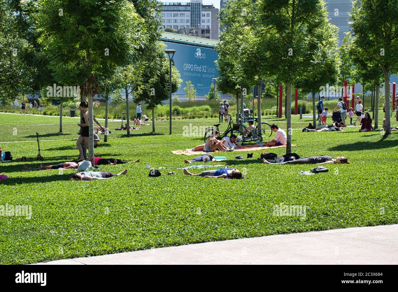 Milan, Italie 06.20.2020: Les gens pratiquant le yoga et profitant du soleil dans social distancer cercles peints sur l'herbe dans la nouvelle Bibliothèque des arbres par Banque D'Images