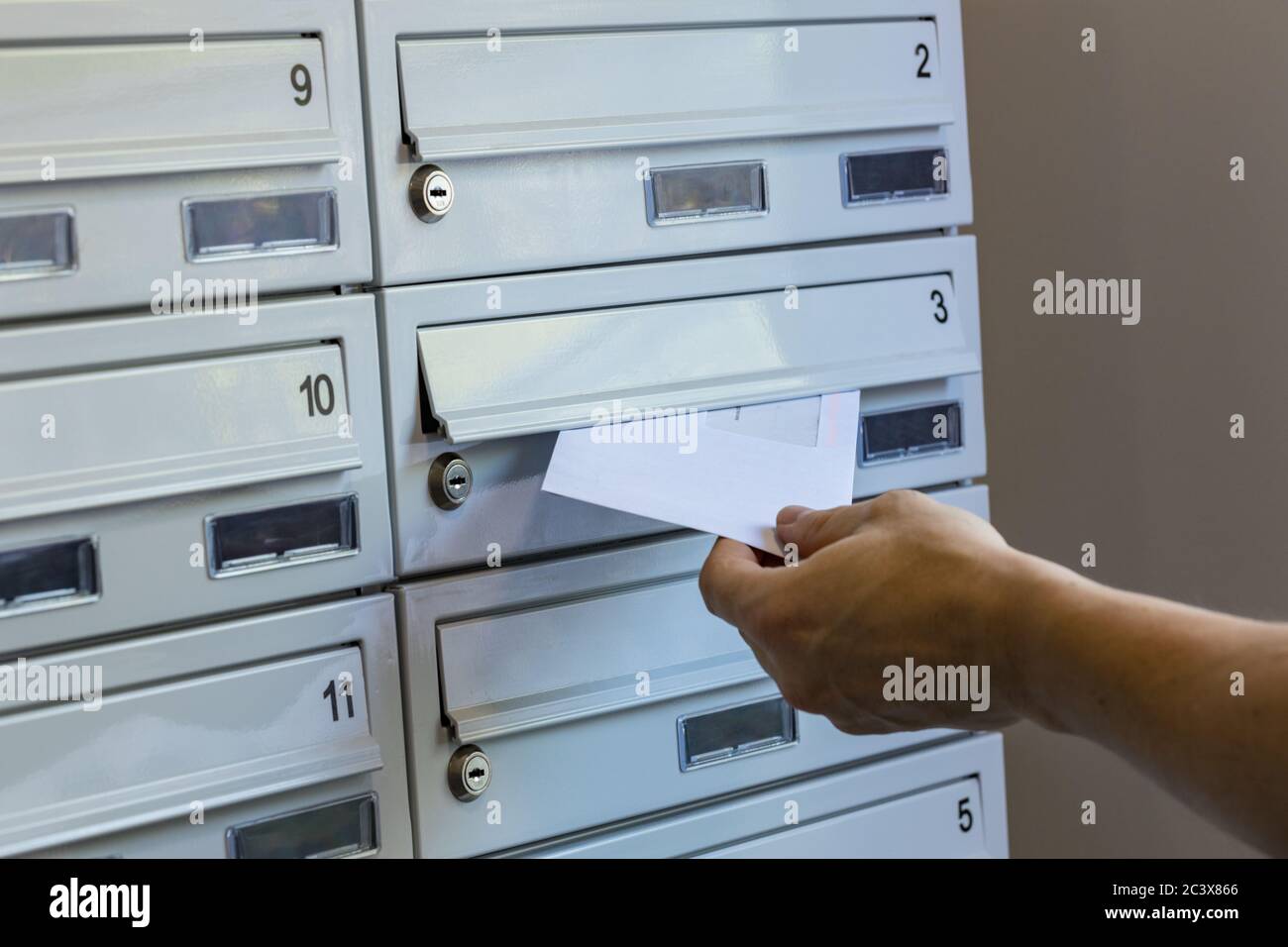 Un postier lance des paquets dans des boîtes aux lettres Banque D'Images