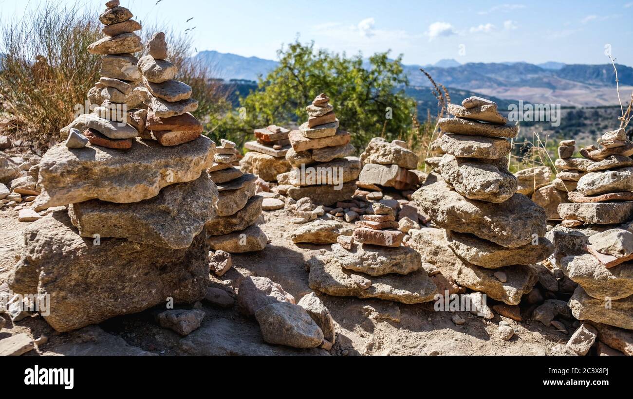Pierres empilées à proximité de Ronda, Espagne. Pieux spirituels de rochers (cairn) pour le calme et la méditation. Montagnes en arrière-plan dans un endroit touristique Banque D'Images