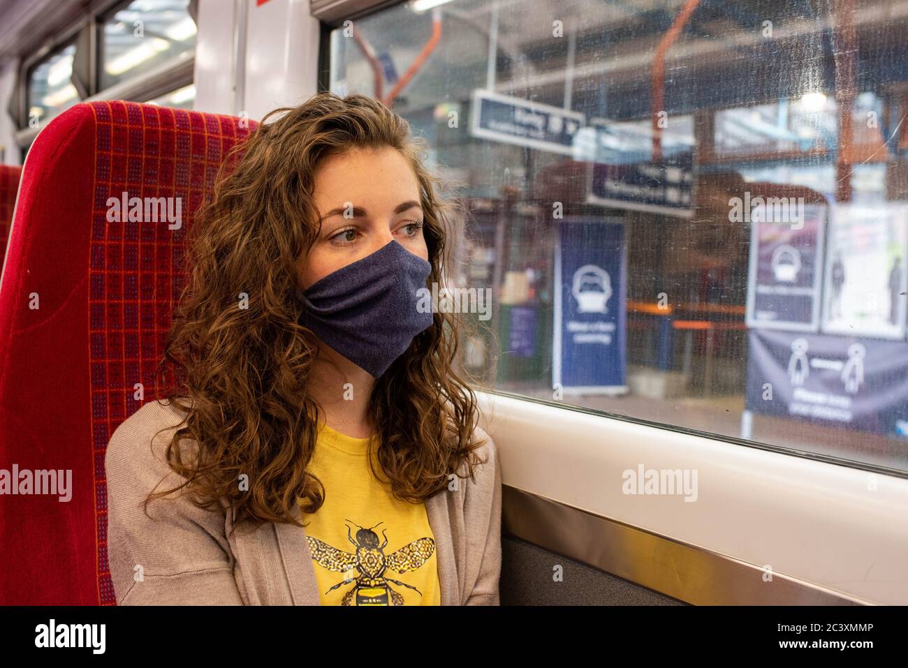 Porter un masque sur le train coronavirus uk Travel rail transport public social distance Restez en sécurité Banque D'Images