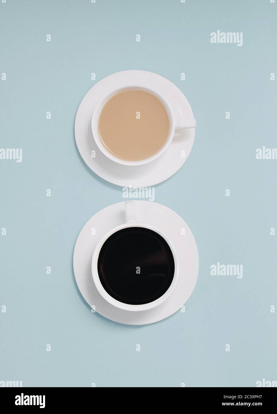 Double café en vue du dessus photo en gros plan de deux tasses de café noir et de café au lait sont debout sur un fond bleu clair Banque D'Images