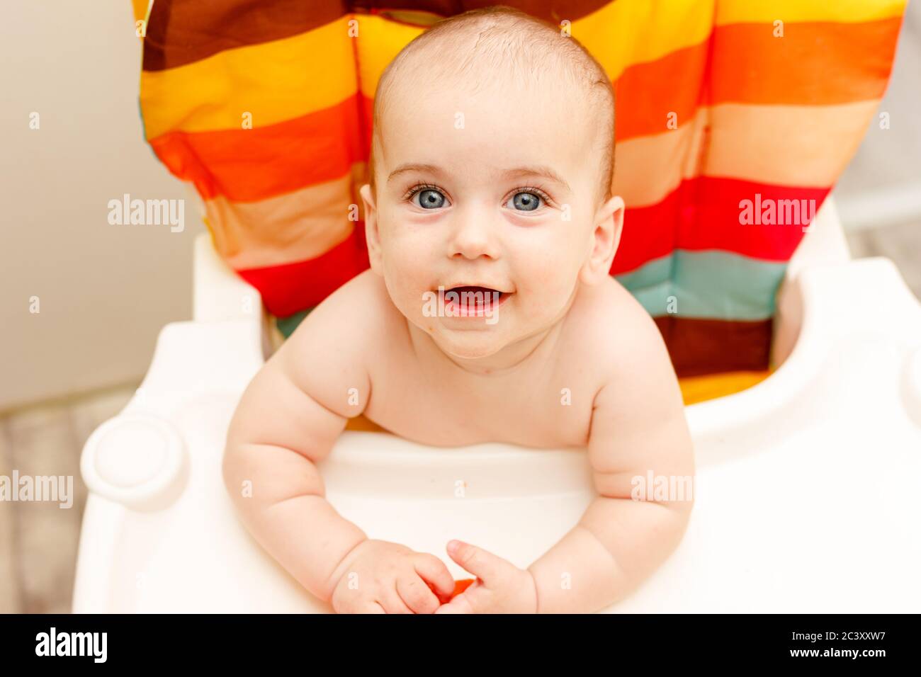 Magnifique bébé garçon peau blanche, mignon bébé garçon de six mois dans  chaise haute de couleur. Vue du dessus Photo Stock - Alamy