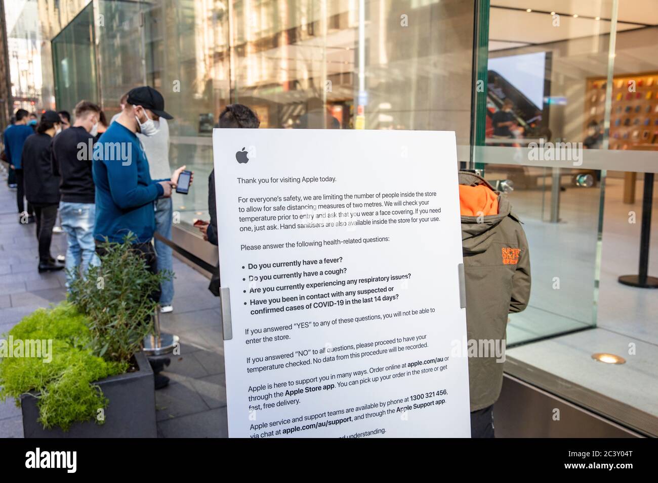 Covid 19 et le magasin phare Apple de Sydney, le personnel de sécurité vérifie la température et la santé des clients qui distribuent des masques faciaux pour entrer dans le magasin Banque D'Images