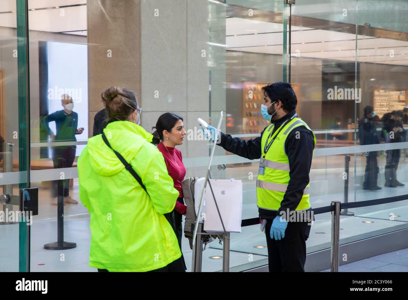 Covid 19 et le magasin phare Apple de Sydney, le personnel de sécurité vérifie la température et la santé des clients qui distribuent des masques faciaux pour entrer dans le magasin Banque D'Images