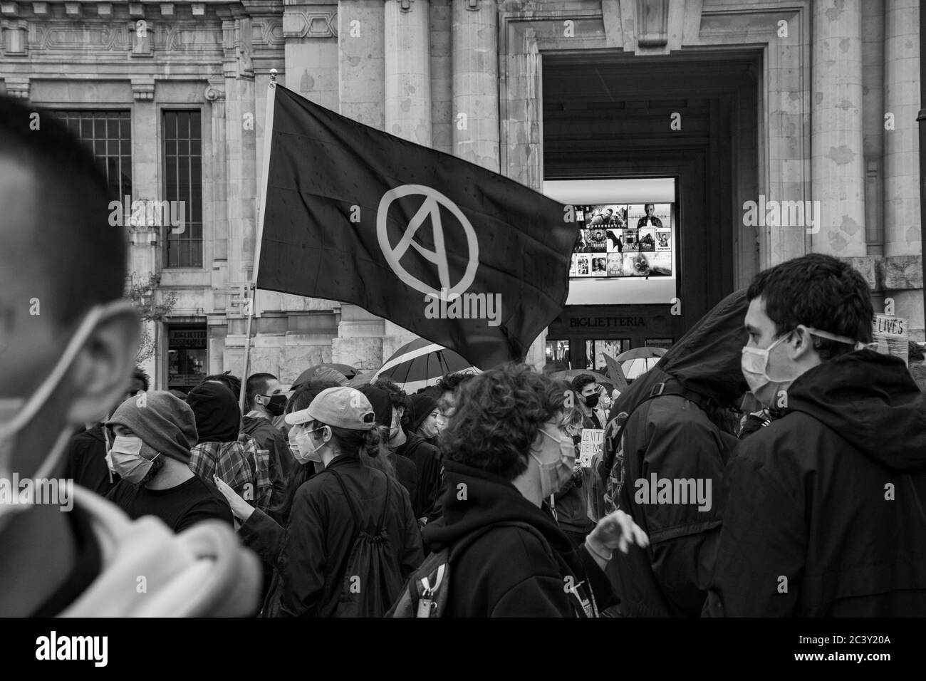 Drapeau de l'anarchie qui flotte pendant l'assemblée de protestation en solidarité avec le mouvement Black Lives Matter devant la gare centrale de Milan. Banque D'Images