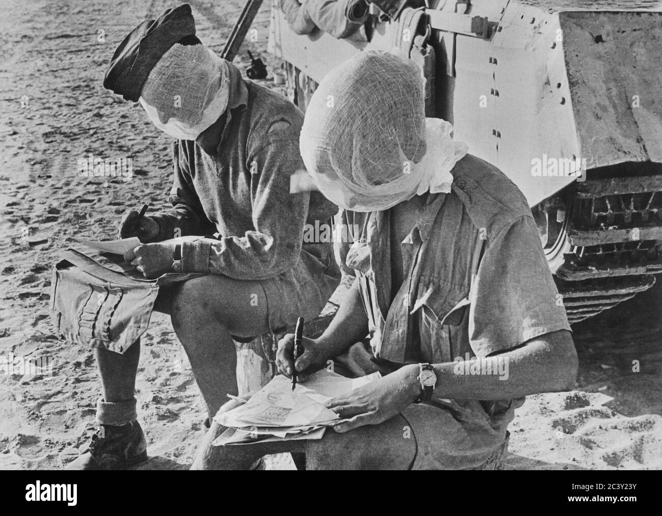 Deux soldats britanniques avec leur tête couverte de moustiquaires, assis près de Tank Writing Letters, Western Desert, Egypte, British Official photo, 1942 Banque D'Images