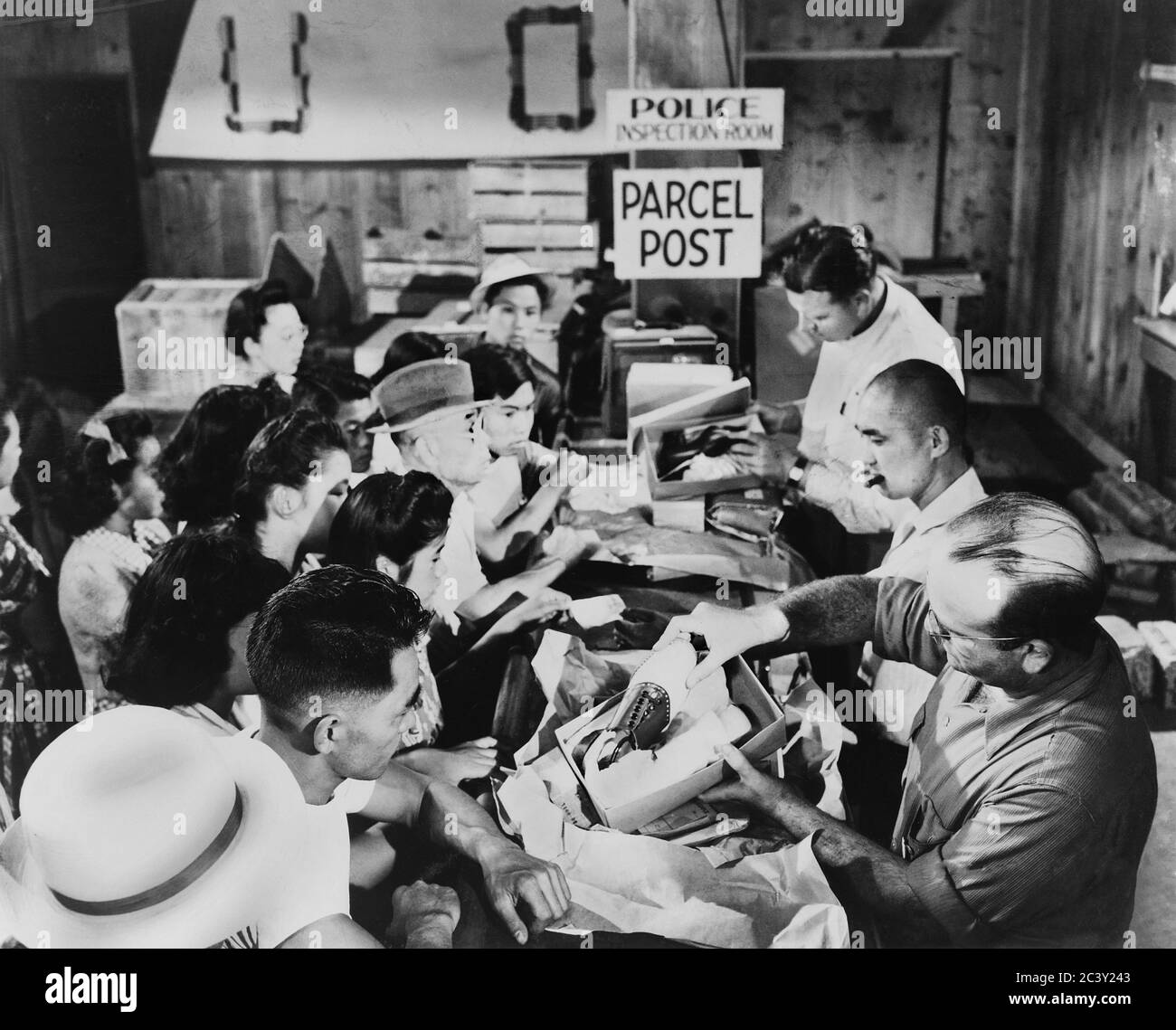 Les Japonais américains se réunissent dans la salle d'inspection de la police pour recevoir des colis qui sont inspectés au centre de détention de Stockton, Californie, États-Unis, U.S. Army signal corps, 1942 Banque D'Images