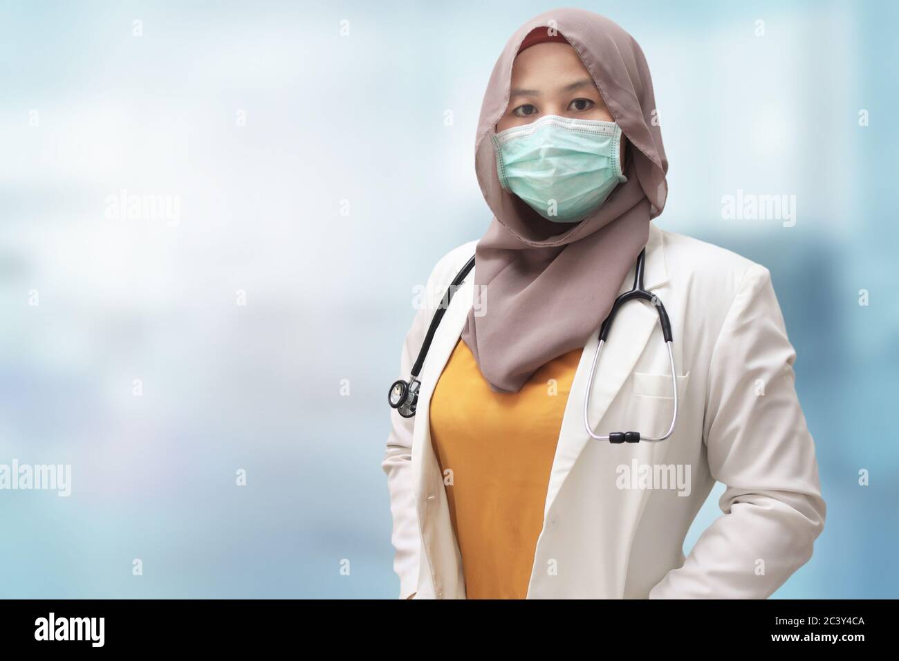 Femme musulmane médecin portant hijab et costume, debout avec masque facial protecteur , prêt à combattre le coronavirus covid19 pandémie mondiale Banque D'Images