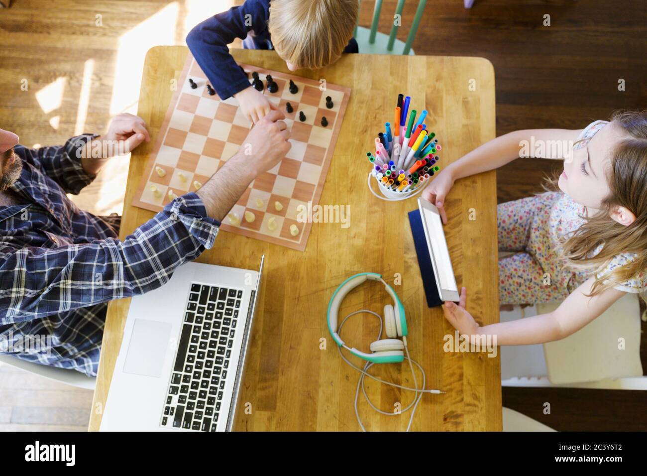 Père travaillant à la maison et jouant avec des enfants (5-6, 6-7) Banque D'Images