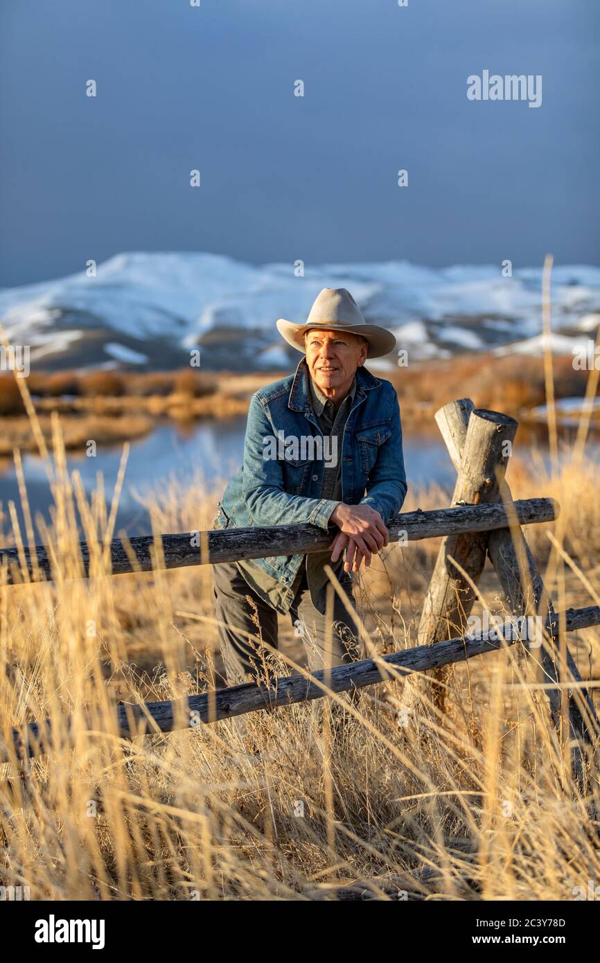 États-Unis, Idaho, Sun Valley, homme senior se penchait contre la clôture en regardant la vue Banque D'Images