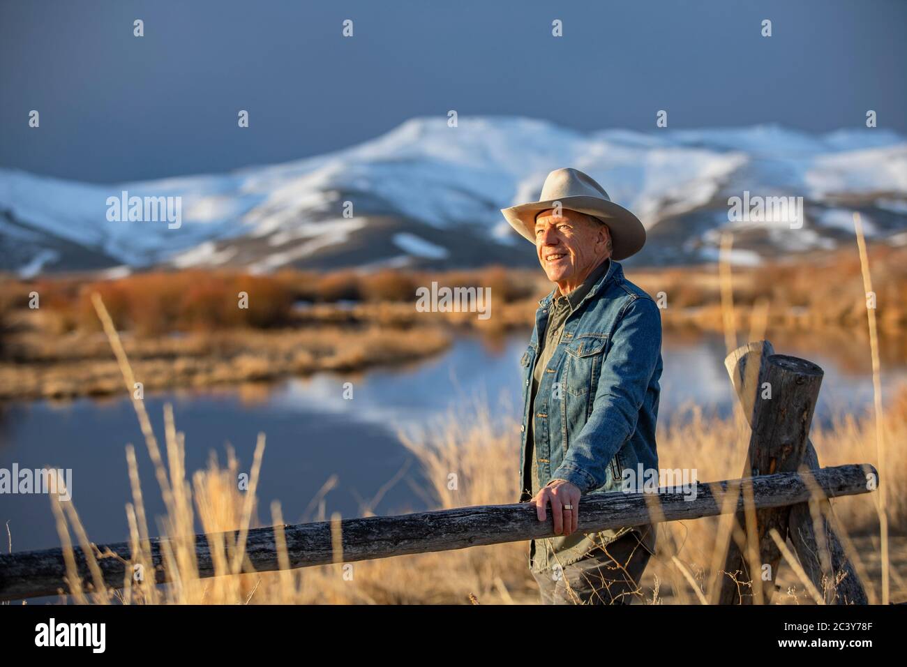 États-Unis, Idaho, Sun Valley, homme senior se penchait contre la clôture en regardant la vue Banque D'Images
