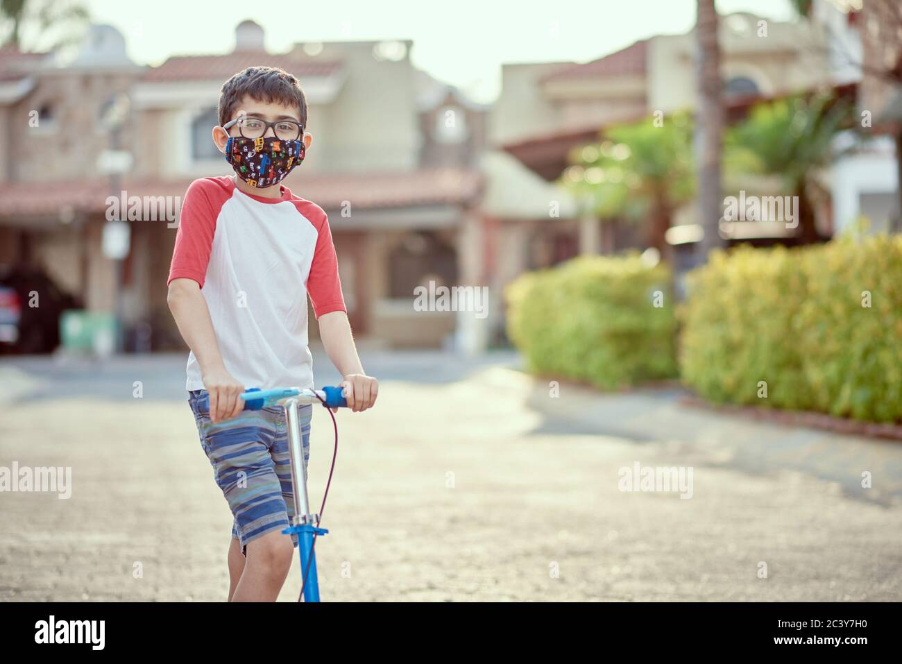 Mexique, Zapopan, Garçon avec masque de visage scooter d'équitation Banque D'Images