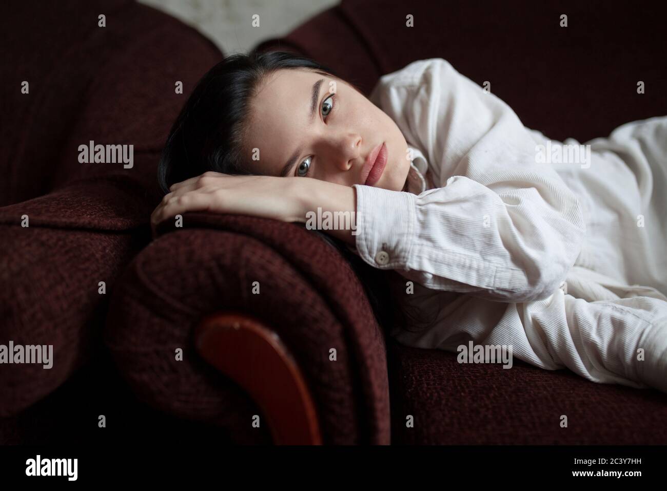 Portrait of young woman lying on sofa Banque D'Images