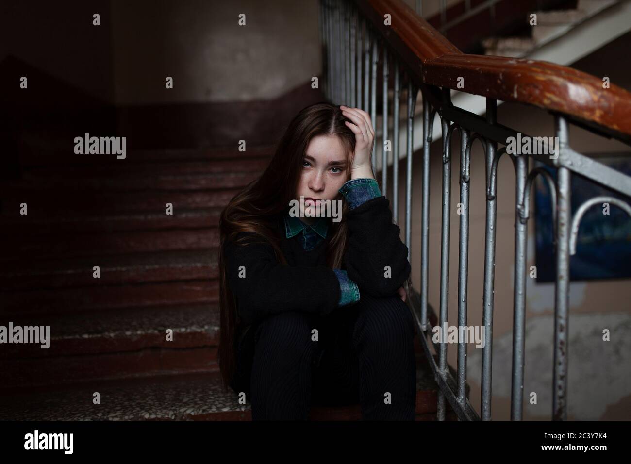 Portrait of young woman sitting on stairs Banque D'Images