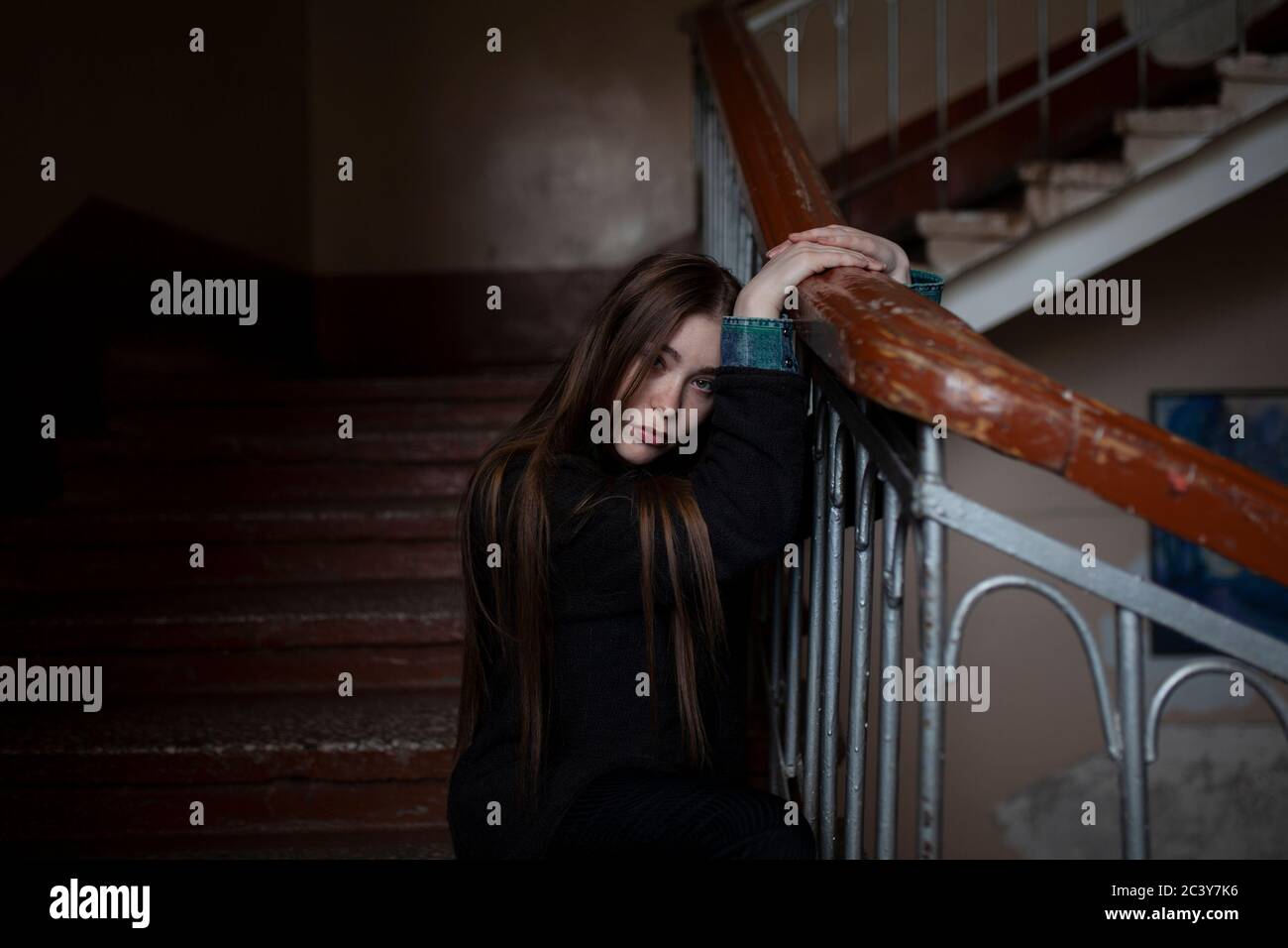 Portrait of young woman sitting on stairs Banque D'Images