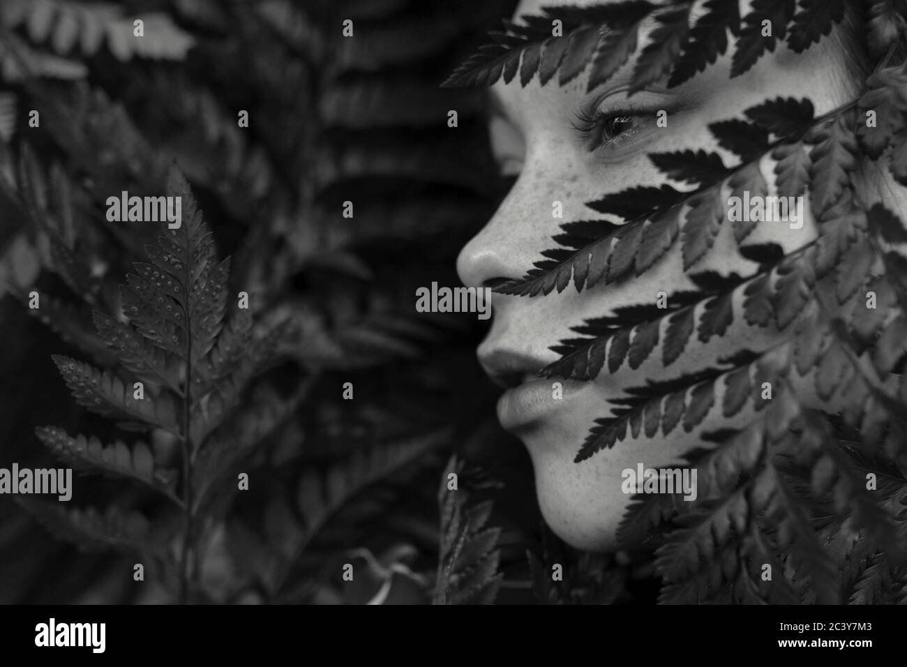 Visage de la jeune femme recouvert de plantes Banque D'Images