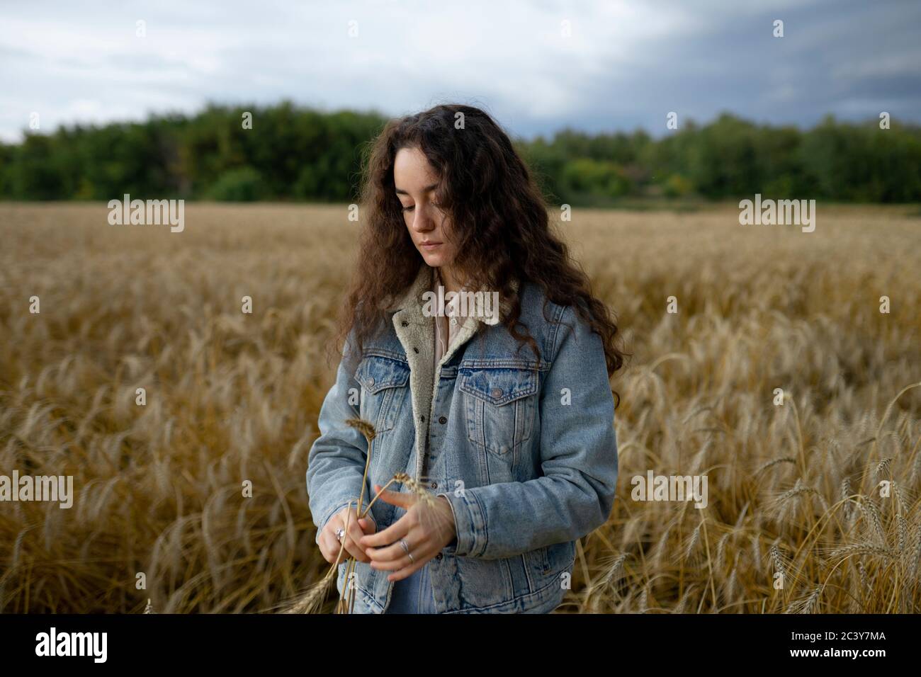 Russie, Omsk, jeune femme debout dans le champ de blé et tenant du blé Banque D'Images