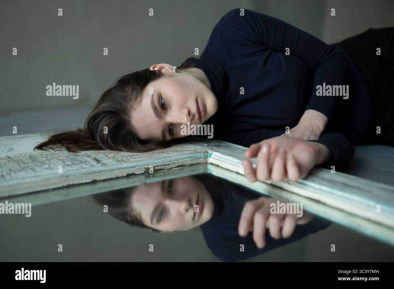 Adolescente couchée par un miroir Banque D'Images