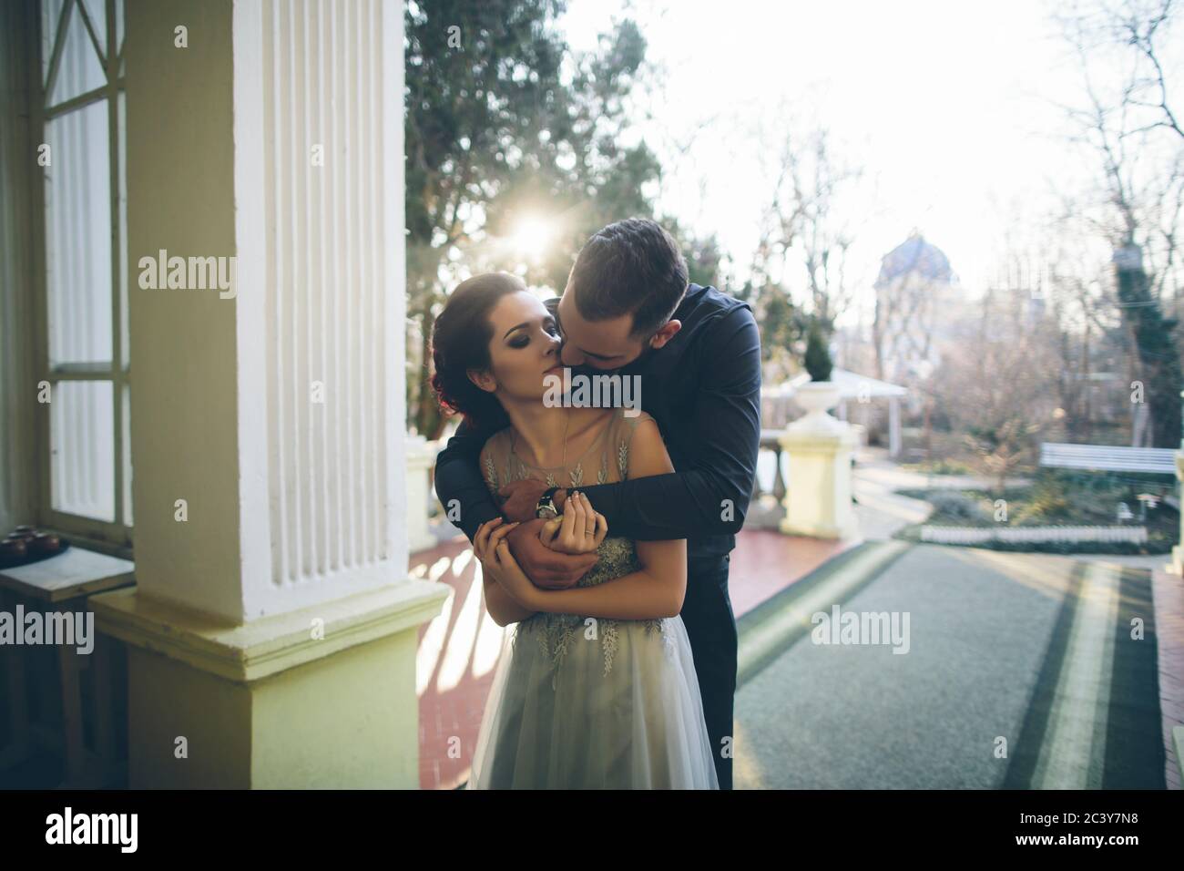 Couple nouvellement mariés embrassant sur la terrasse Banque D'Images