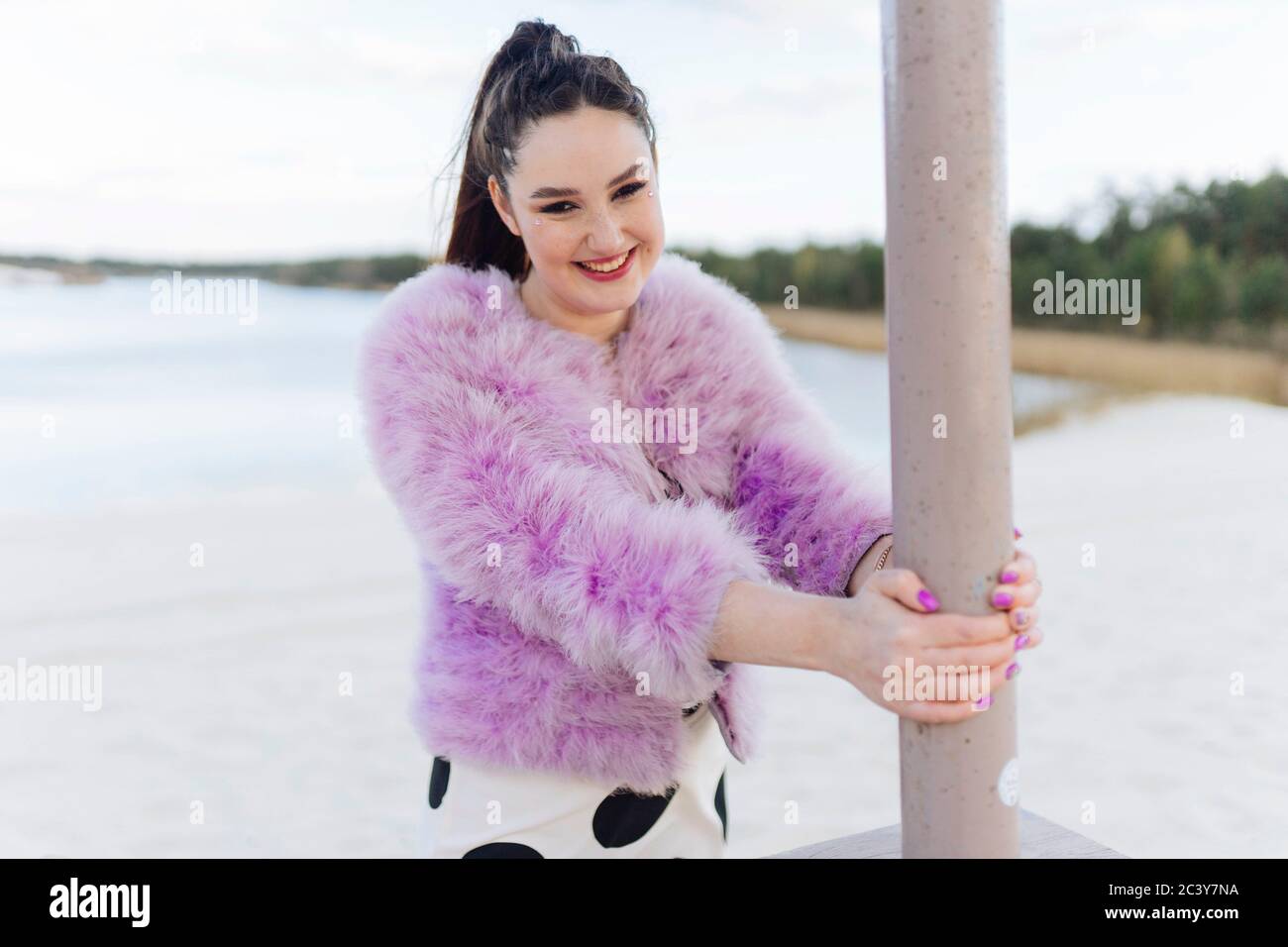 Biélorussie, Minsk, Portrait de jeune femme en manteau de cur rose sur la plage Banque D'Images