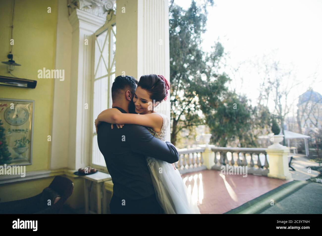 Couple nouvellement mariés embrassant sur la terrasse Banque D'Images