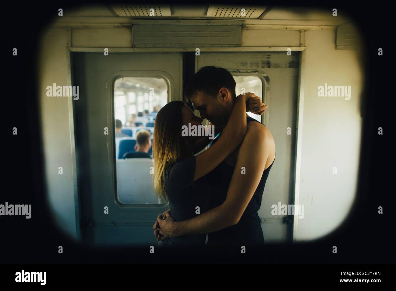 Un jeune couple embrasse en train Banque D'Images