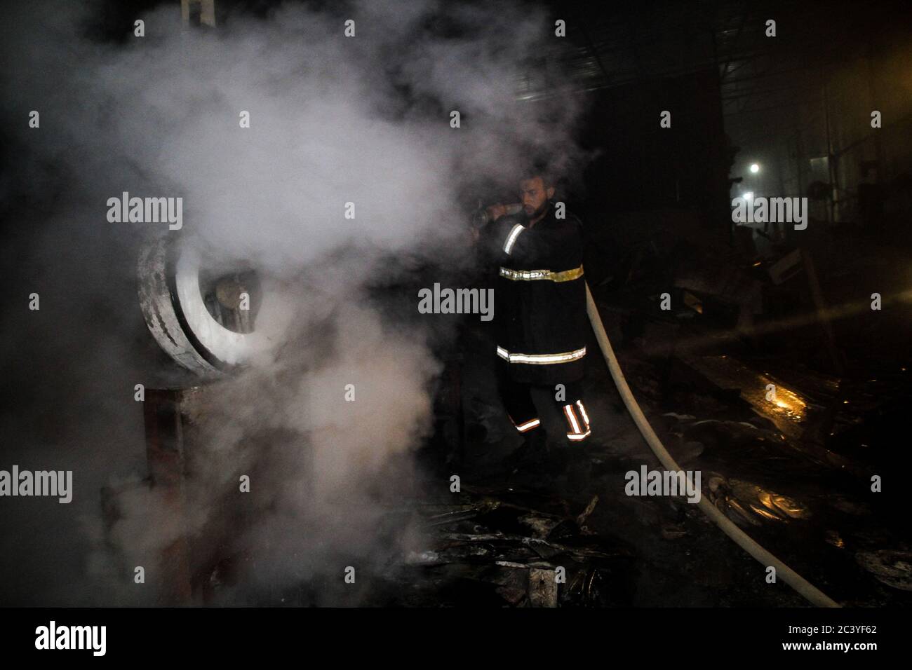 22 juin 2020 : Gaza, Palestine. 22 juin 2020. Les équipes palestiniennes de la Défense civile travaillent pour éteindre un incendie qui a éclaté dans une installation industrielle à l'est du camp de réfugiés de Jabalia. Le personnel du service de secours a eu du mal à contenir et à mettre le feu, ce qui a causé une destruction grave de l'usine. Le bâtiment brûlé est situé près des bureaux de l'Administration civile dans le nord de la bande de Gaza crédit: Ahmad Haaballah/IMAGESLIVE/ZUMA Wire/Alamy Live News Banque D'Images