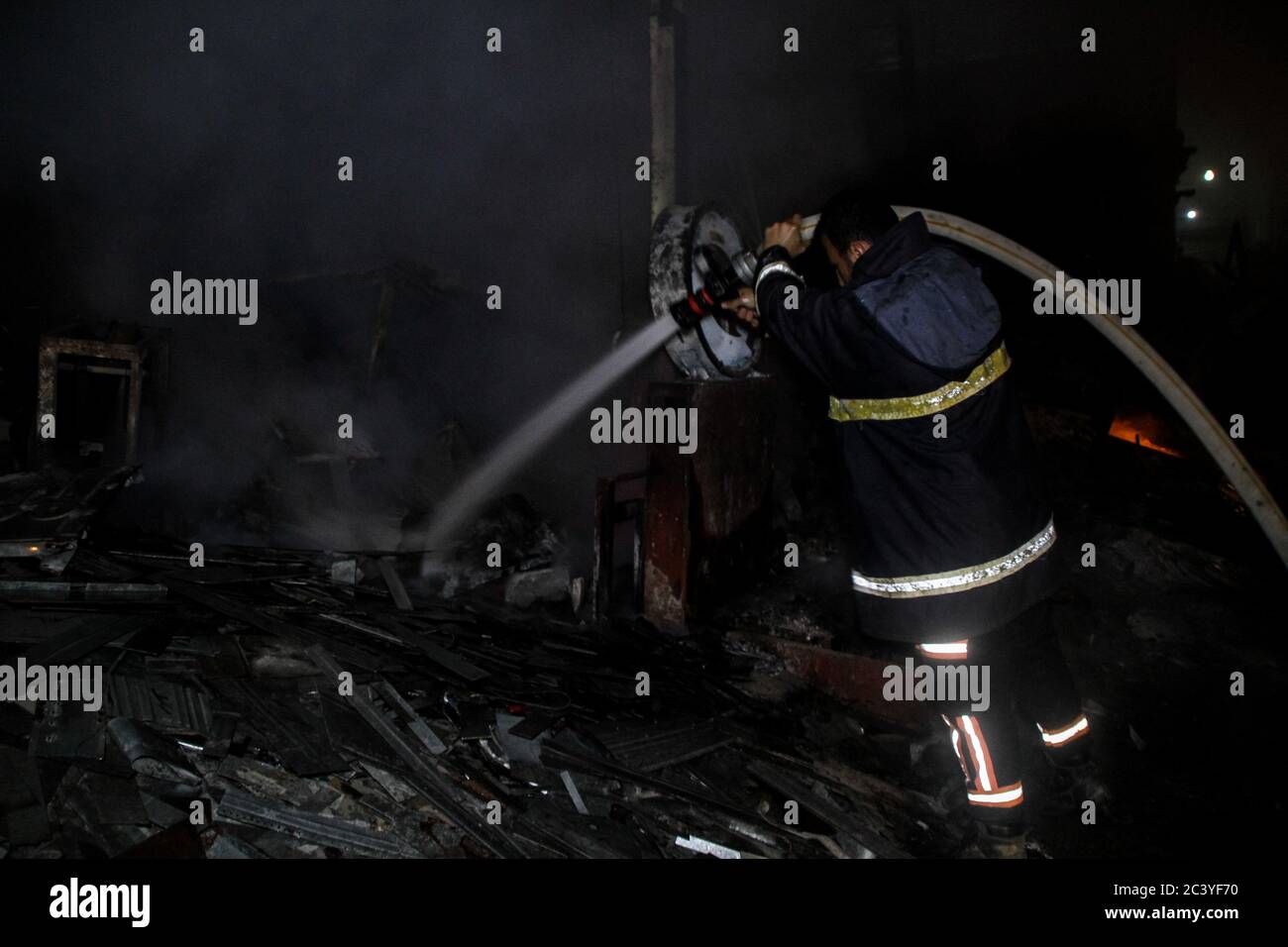 22 juin 2020 : Gaza, Palestine. 22 juin 2020. Les équipes palestiniennes de la Défense civile travaillent pour éteindre un incendie qui a éclaté dans une installation industrielle à l'est du camp de réfugiés de Jabalia. Le personnel du service de secours a eu du mal à contenir et à mettre le feu, ce qui a causé une destruction grave de l'usine. Le bâtiment brûlé est situé près des bureaux de l'Administration civile dans le nord de la bande de Gaza crédit: Ahmad Haaballah/IMAGESLIVE/ZUMA Wire/Alamy Live News Banque D'Images