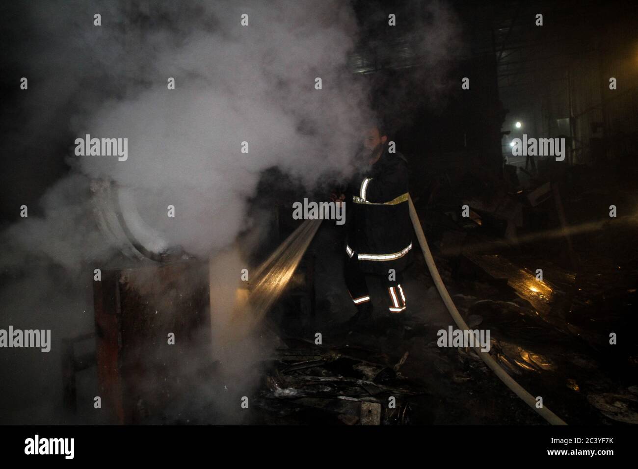 22 juin 2020 : Gaza, Palestine. 22 juin 2020. Les équipes palestiniennes de la Défense civile travaillent pour éteindre un incendie qui a éclaté dans une installation industrielle à l'est du camp de réfugiés de Jabalia. Le personnel du service de secours a eu du mal à contenir et à mettre le feu, ce qui a causé une destruction grave de l'usine. Le bâtiment brûlé est situé près des bureaux de l'Administration civile dans le nord de la bande de Gaza crédit: Ahmad Haaballah/IMAGESLIVE/ZUMA Wire/Alamy Live News Banque D'Images