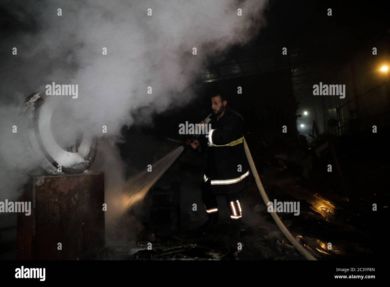22 juin 2020 : Gaza, Palestine. 22 juin 2020. Les équipes palestiniennes de la Défense civile travaillent pour éteindre un incendie qui a éclaté dans une installation industrielle à l'est du camp de réfugiés de Jabalia. Le personnel du service de secours a eu du mal à contenir et à mettre le feu, ce qui a causé une destruction grave de l'usine. Le bâtiment brûlé est situé près des bureaux de l'Administration civile dans le nord de la bande de Gaza crédit: Ahmad Haaballah/IMAGESLIVE/ZUMA Wire/Alamy Live News Banque D'Images
