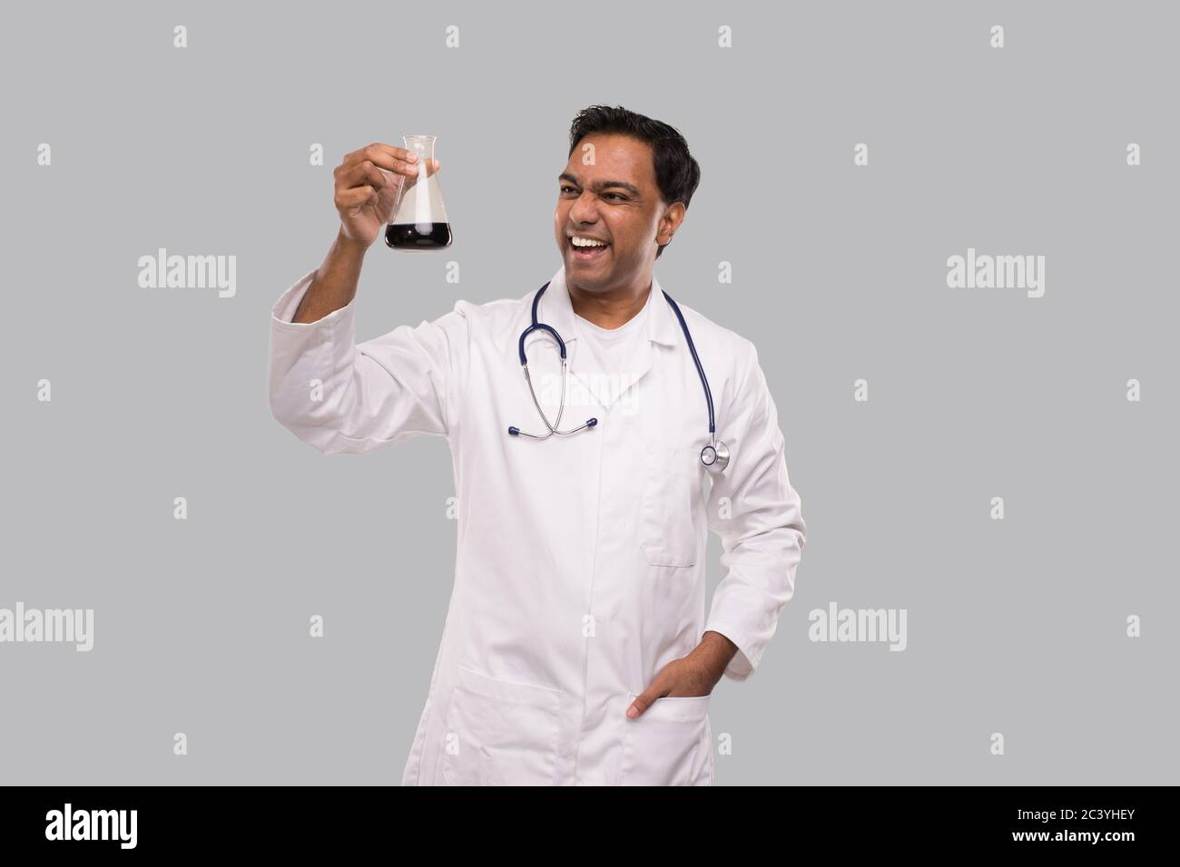 Homme Docteur excitée de contrôle de sang analyse avec bonne idée. Indian Man Docteur Examing tube de sang isolé. Médecine, Science, concept de vie saine Banque D'Images