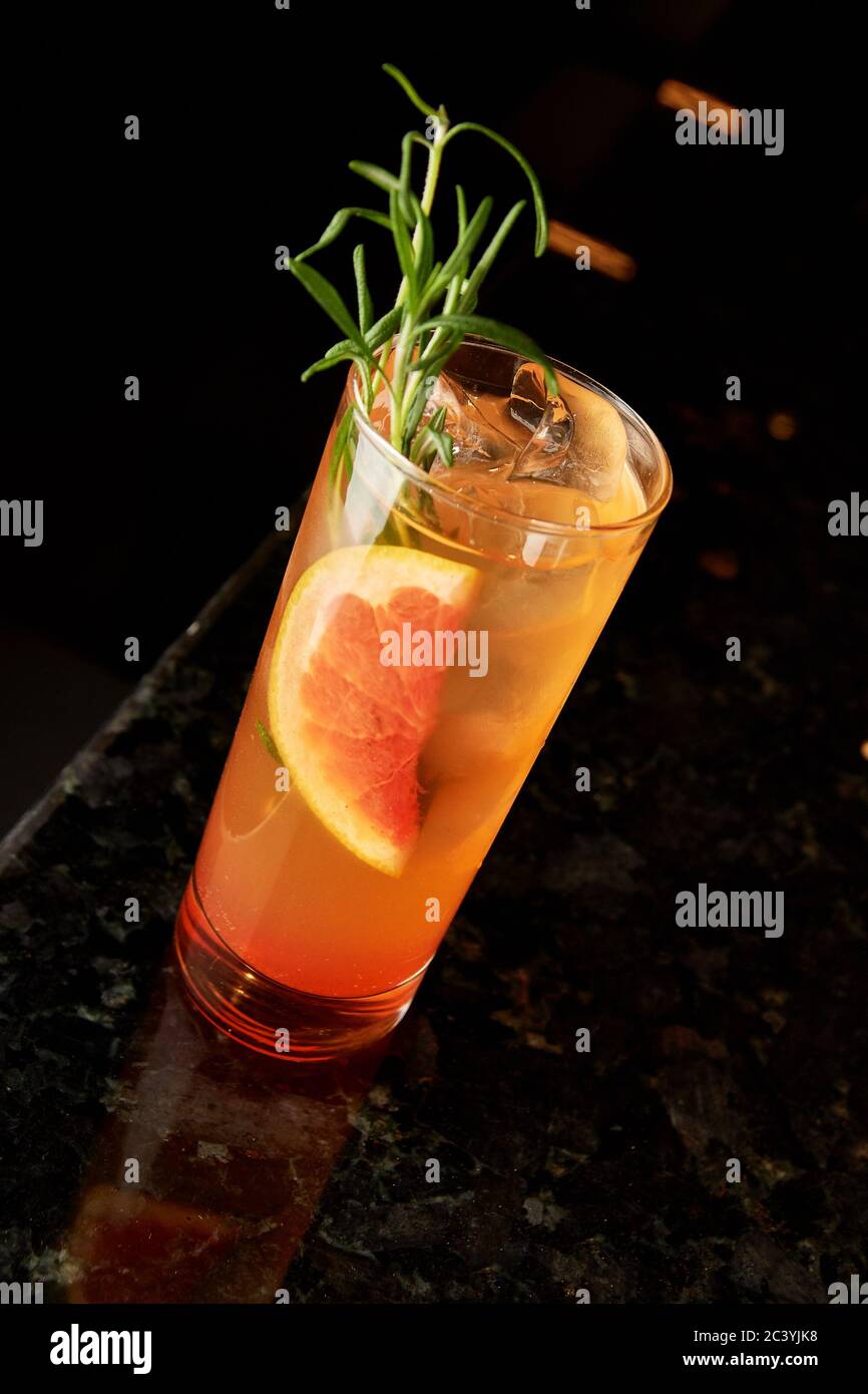 Cocktail de gin, liqueur de carotte, tonique, orange et romarin et tonique  sur comptoir en marbre noir Photo Stock - Alamy