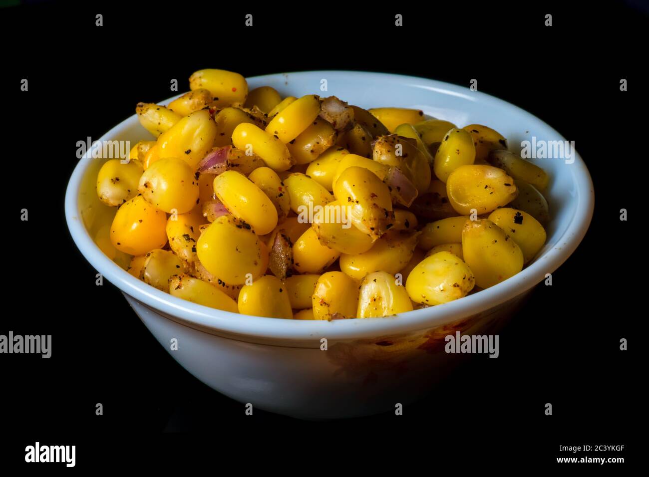 Maïs sucré au fromage américain dans un bol en verre avec de l'espace pour le texte sur fond sombre. Vue avant Banque D'Images