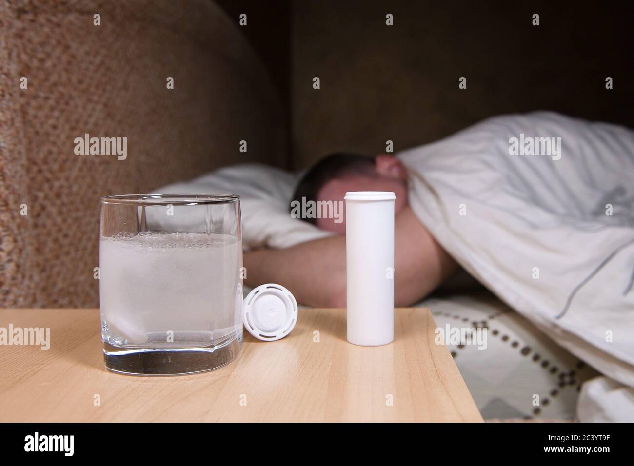 le comprimé se dissout dans l'eau, et à l'arrière-plan, un homme se lance et tourne Banque D'Images