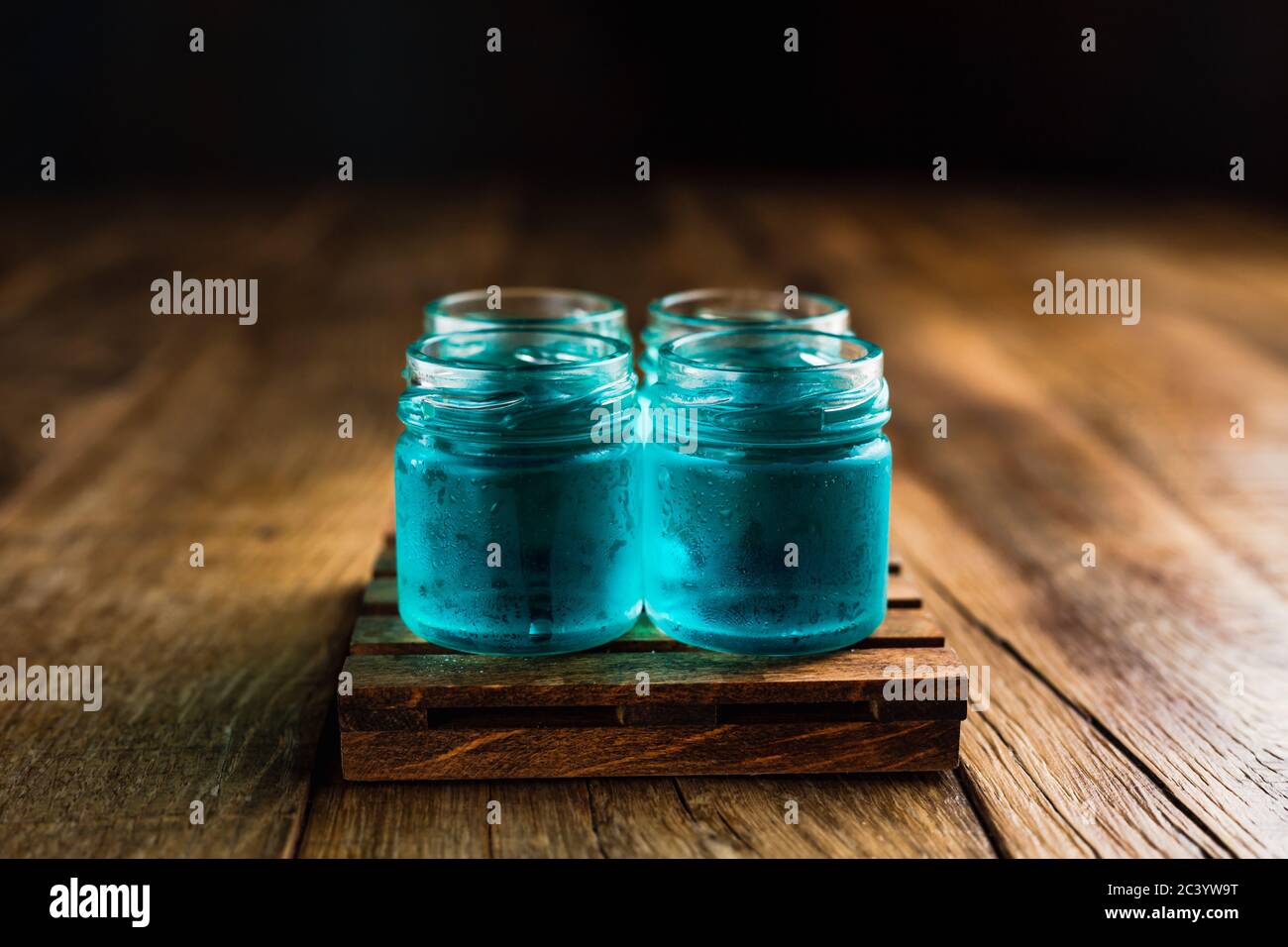 Des tireurs alcoolisés de couleur bleue ou des boissons sur une table en bois Banque D'Images