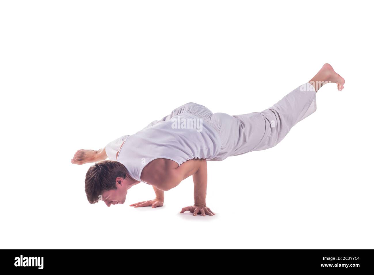 Homme pratiquant le yoga faisant la « posture du corbeau à une jambe » sur fond blanc. EKA pada bakasana Banque D'Images