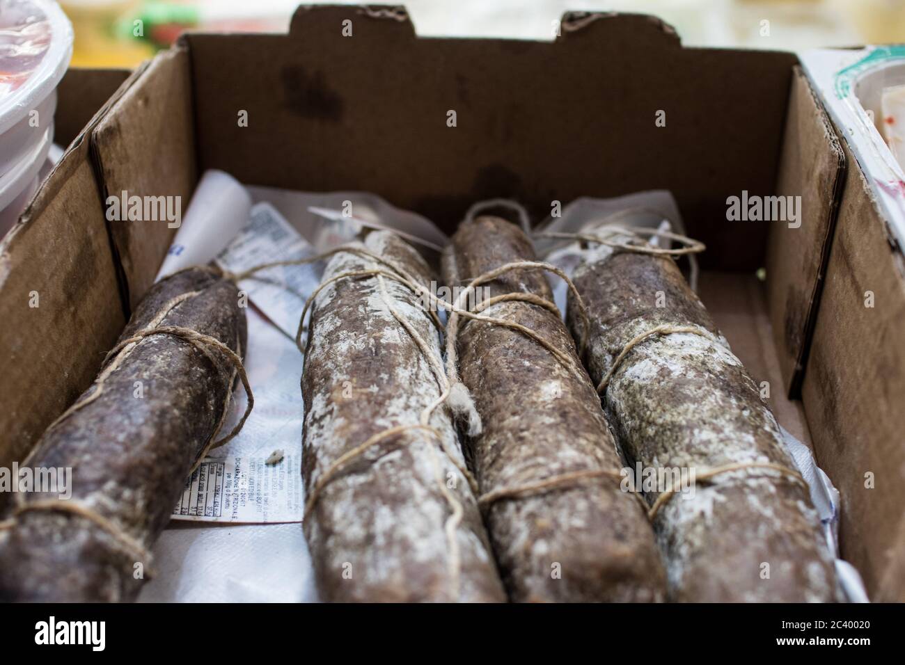 Quatre salades de sanglier assaisonnées dans une cassette sur le marché. Salami lié avec des moules blancs Banque D'Images