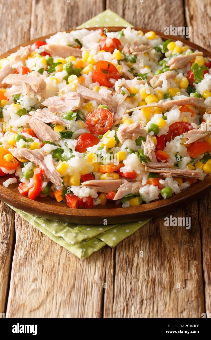 Salade italienne de riz, thon et légumes frais dans une assiette sur la table. Verticale Banque D'Images