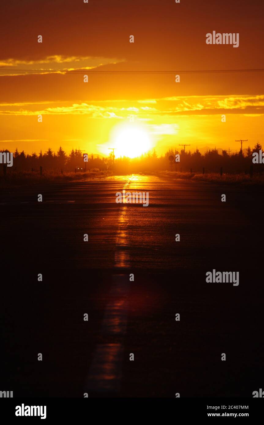 Séquence d'images d'un coucher de soleil du même point de vue, le réglage  des soleils dans la route, le silho bordé d'arbres Photo Stock - Alamy